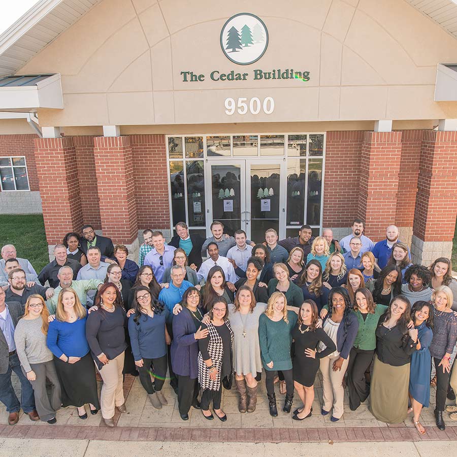 A Small Group of People in a Community with Their Hands in a Circle