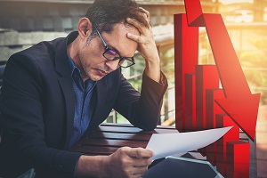 disappointed man holding paper with graphs going down | problem with hoa management companies