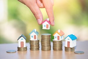 Mini house on stack of coins | reasons to serve the HOA board