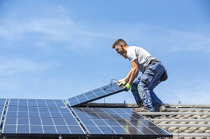 man installing solar panel system | save energy during spring