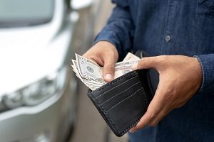 person holding and taking money out of pocket | tips for moving into an hoa community