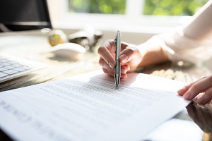 Hand Signing Contract With Pen Over Desk In Office | vendor agreements