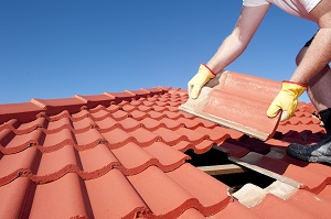 man replacing roof tile of house | hoa maintenance