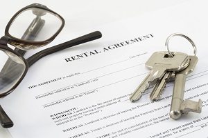 rental agreement document with a set of house keys and glasses | hoa rules for renters