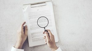 Man hands looking document with magnifying glass | hoa rules for renters