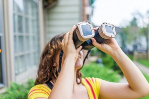 woman looking through binoculars | HOA neighborhood watch