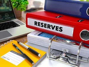 pen and notebook, laptop and ring binder with reserves writing | tips for handling hoa reserve funds