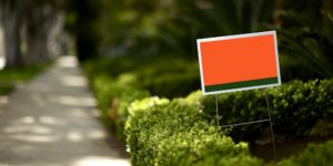 political sign behind bushes on the street | hoa signs