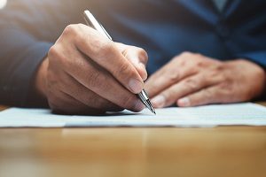 man writing a letter | hoa harassment law