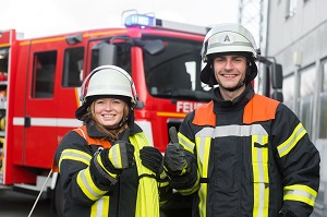 two firefighters smiling with fire truck in the background | fire safety tips