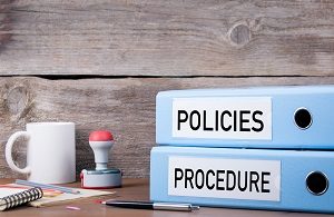 Policies and Procedure wtitten on two binders on desk | how to run an hoa