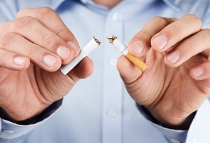 hands breaking up cigarette | hoa smoking restrictions