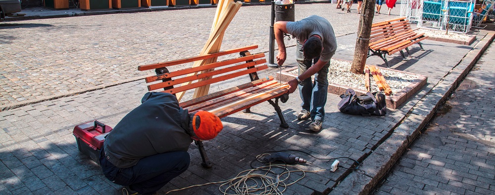 Men are repairing a bench | list of capital improvements