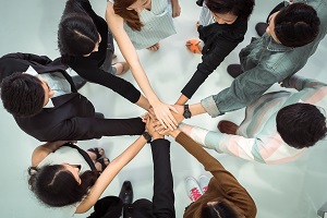 a group of people piling hands together | hoa issues