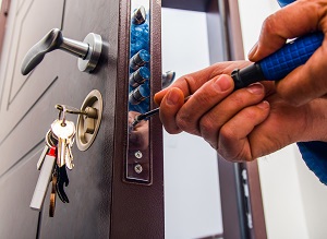 man fixing the door lock with screwdriver | hoa crime prevention