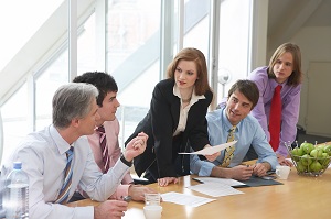 woman standing while talking to a group of people in a meeting | hoa means