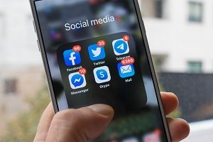 mobile phone screen with icons of social media applications and email | best social media practices for HOA