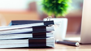 pile documents placed on a desk | hire an HOA lawyer
