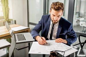 man in suit doing paper works | community association management