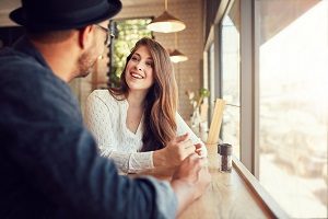 Smiling woman sitting in a cafe and talking to a man | hoa dysfunction