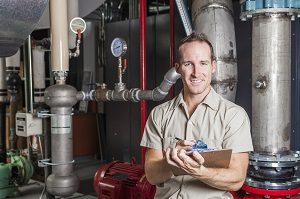 A Technician inspecting heating system in boiler room | hoa natural disaster plan