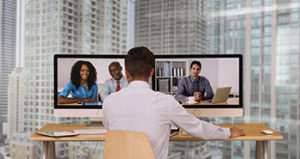 Man uses two monitors for teleconference | hoa board responsibilities