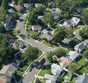 aerial view of east coast suburban homes outside New York City on bright summer day | planned unit development pros and cons